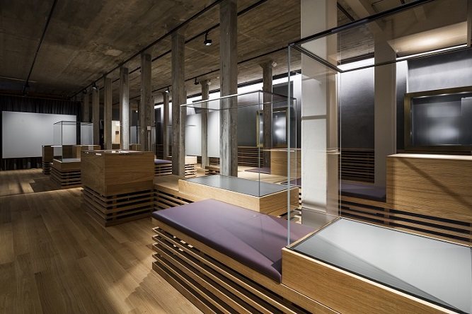 Ausstellungsraum mit Sitzbänken und Vitrinen